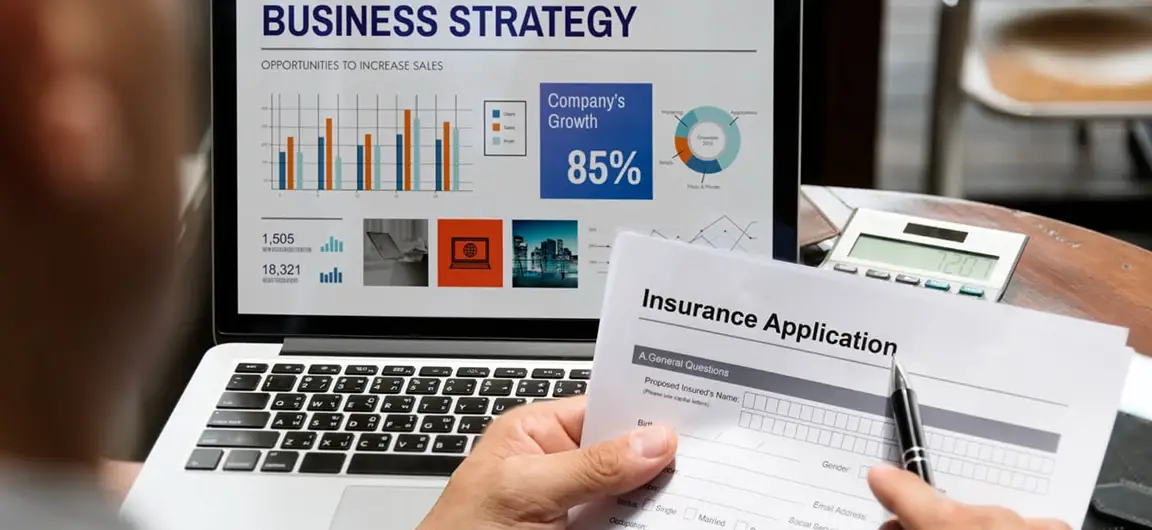 Person Reviewing Insurance Application with Business Strategy Charts on Laptop