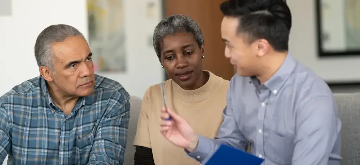 Insurance Agent Discussing Policies with a Couple in an Office Setting